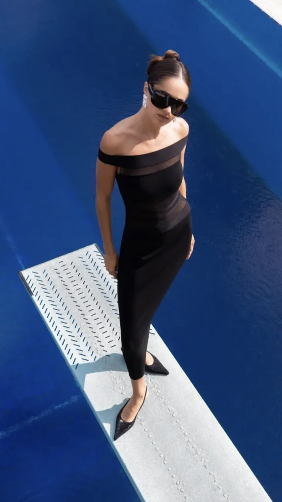 Vestido negro y gafas oscuras junto a una piscina azul — estilismo de Manel Guisado