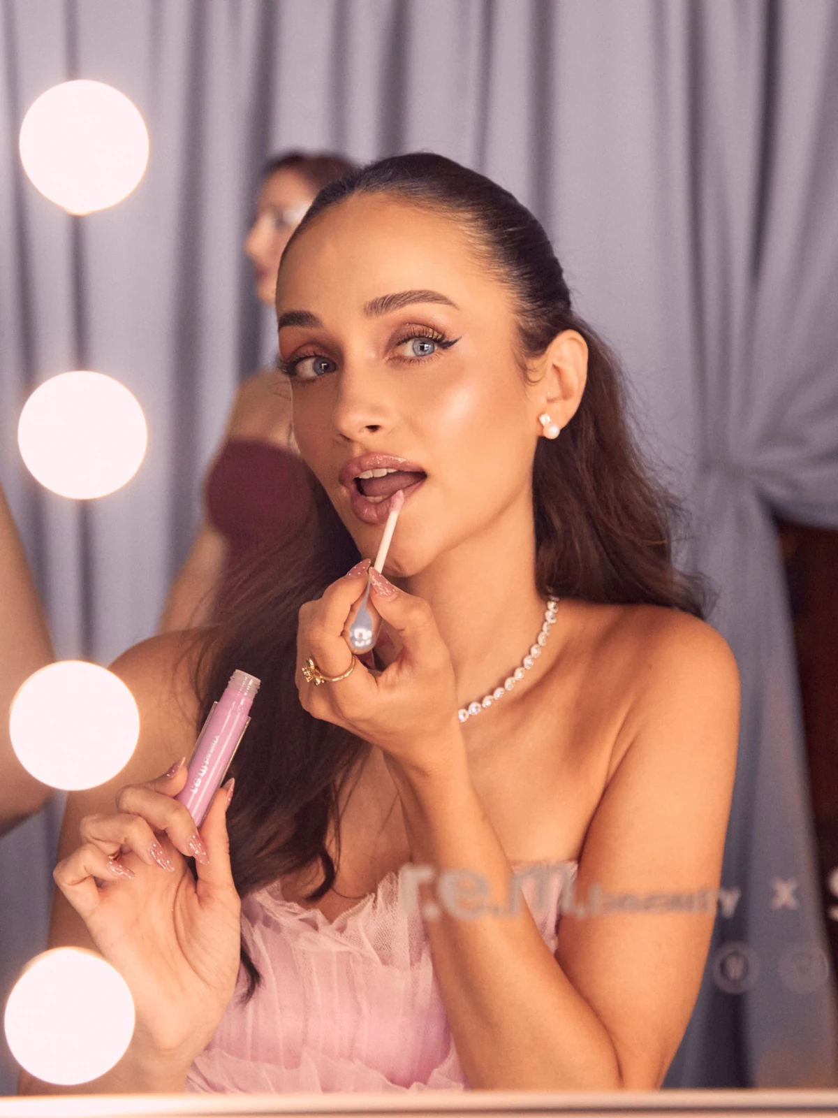 Alicia Revilla applying r.e.m. beauty lip gloss — styling by Manel Guisado