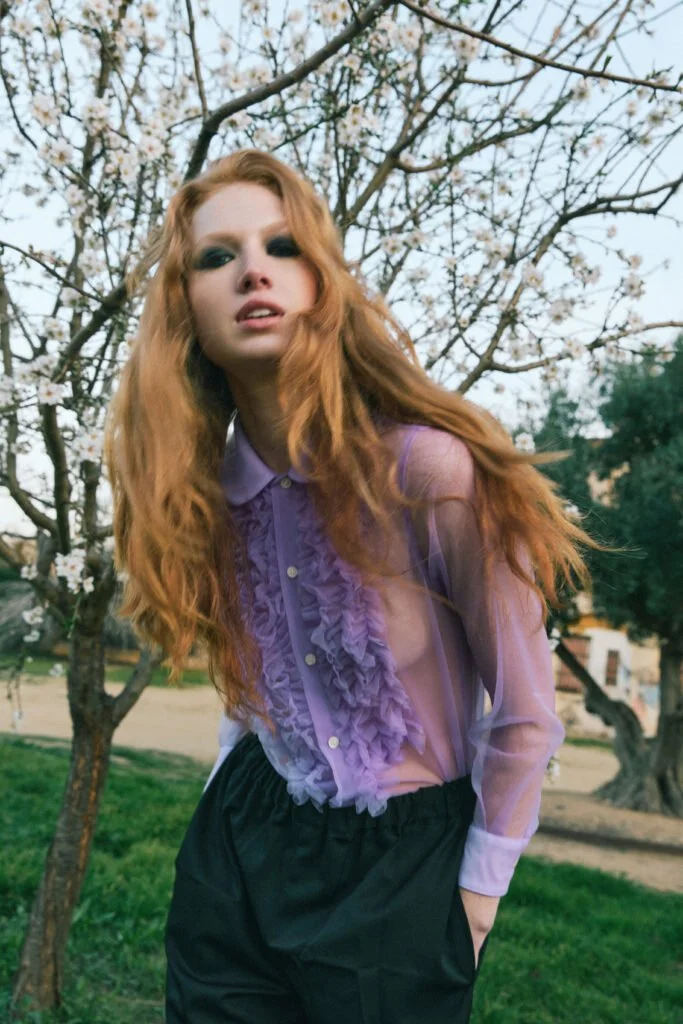 Blusa violeta y falda negra entre árboles — estilismo de Manel Guisado