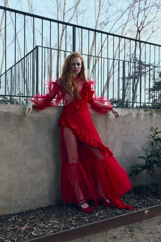 Traje rojo junto a una estructura metálica — estilismo de Manel Guisado