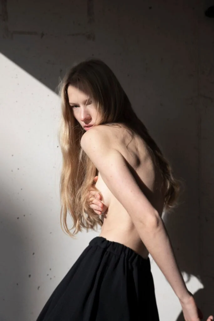 Retrato con vestido oscuro junto a un muro — estilismo de Manel Guisado