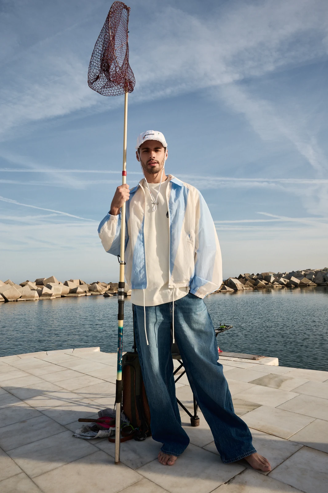 Waterfront fashion portrait with fishing net for Victor Magazine Brasil — styling by Manel Guisado